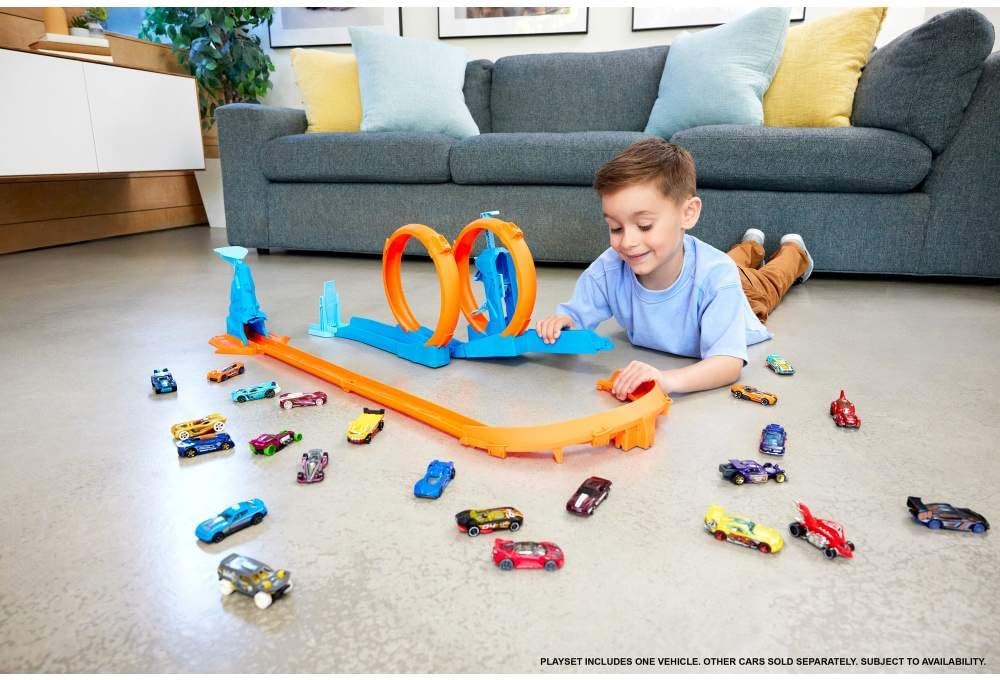 Hot Wheels toy car track set with triple loops and a 1:64 scale car on a colorful racing track.