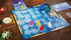 Dixit family board game by Playzokids, featuring illustrated cards and game components on a wooden table.